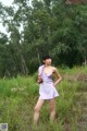 A woman in a purple dress standing in a field.