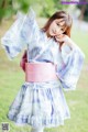 A woman in a blue and pink kimono posing for a picture.