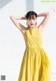 A woman in a yellow dress posing for a magazine.