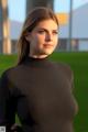 A woman in a black shirt standing in a field.